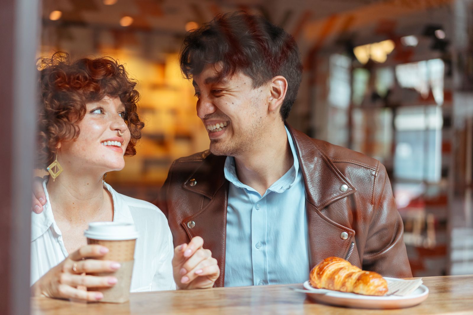 Photographed couple laughing together at a café